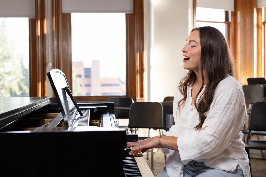 Olivia Pess singing at a piano.